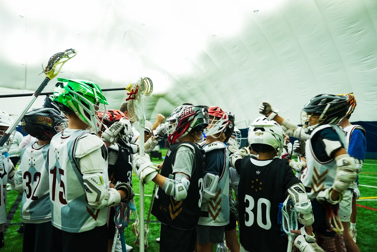 A group of young players and their coach huddle together