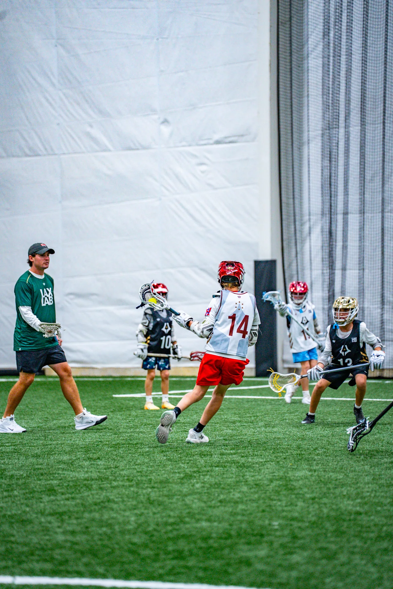 Players run through a lacrosse drill inside the fieldhouse
