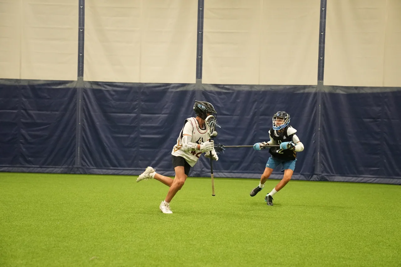 Two athletes practice attacking and defending on indoor turf