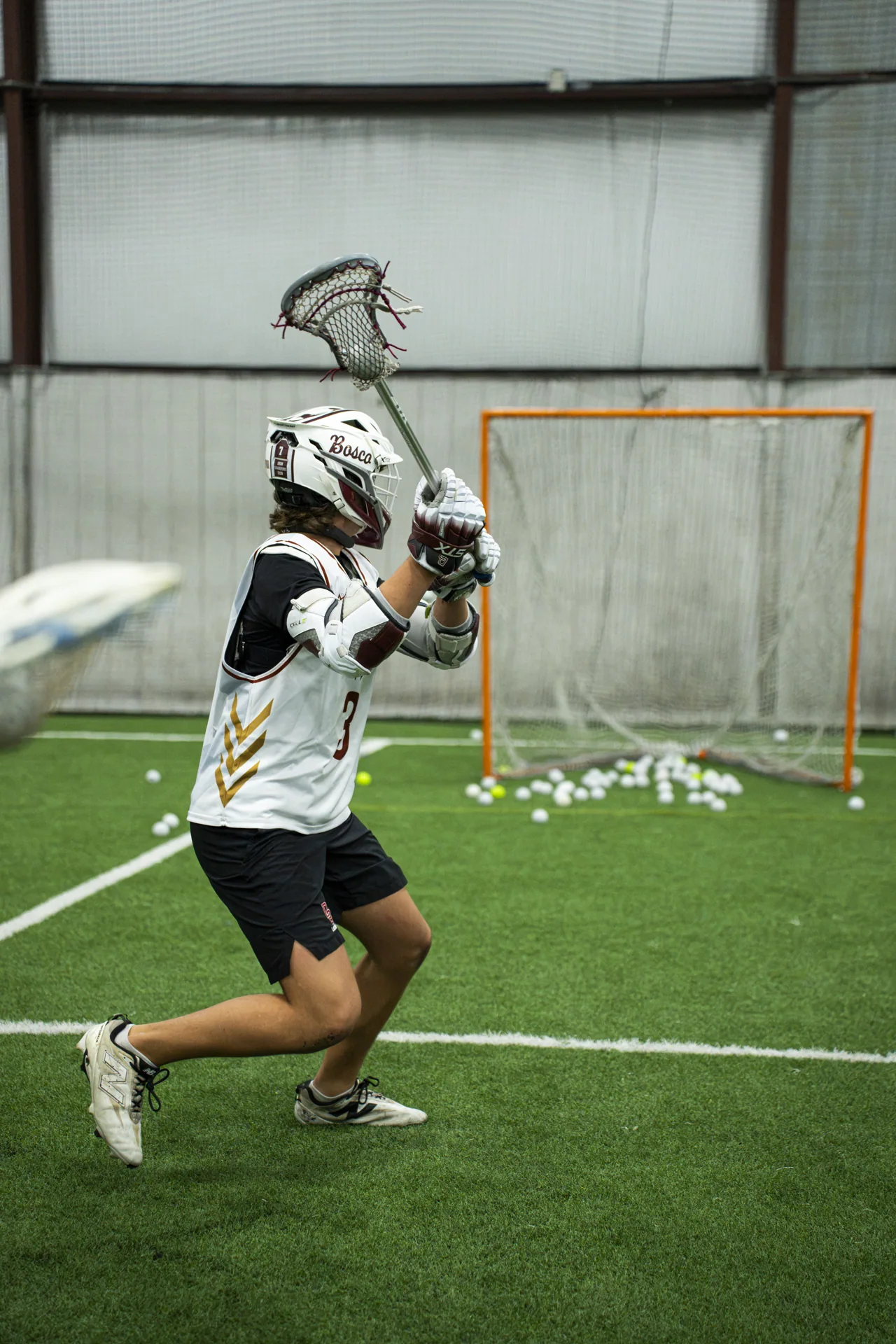An athlete winds up for a lacrosse shot