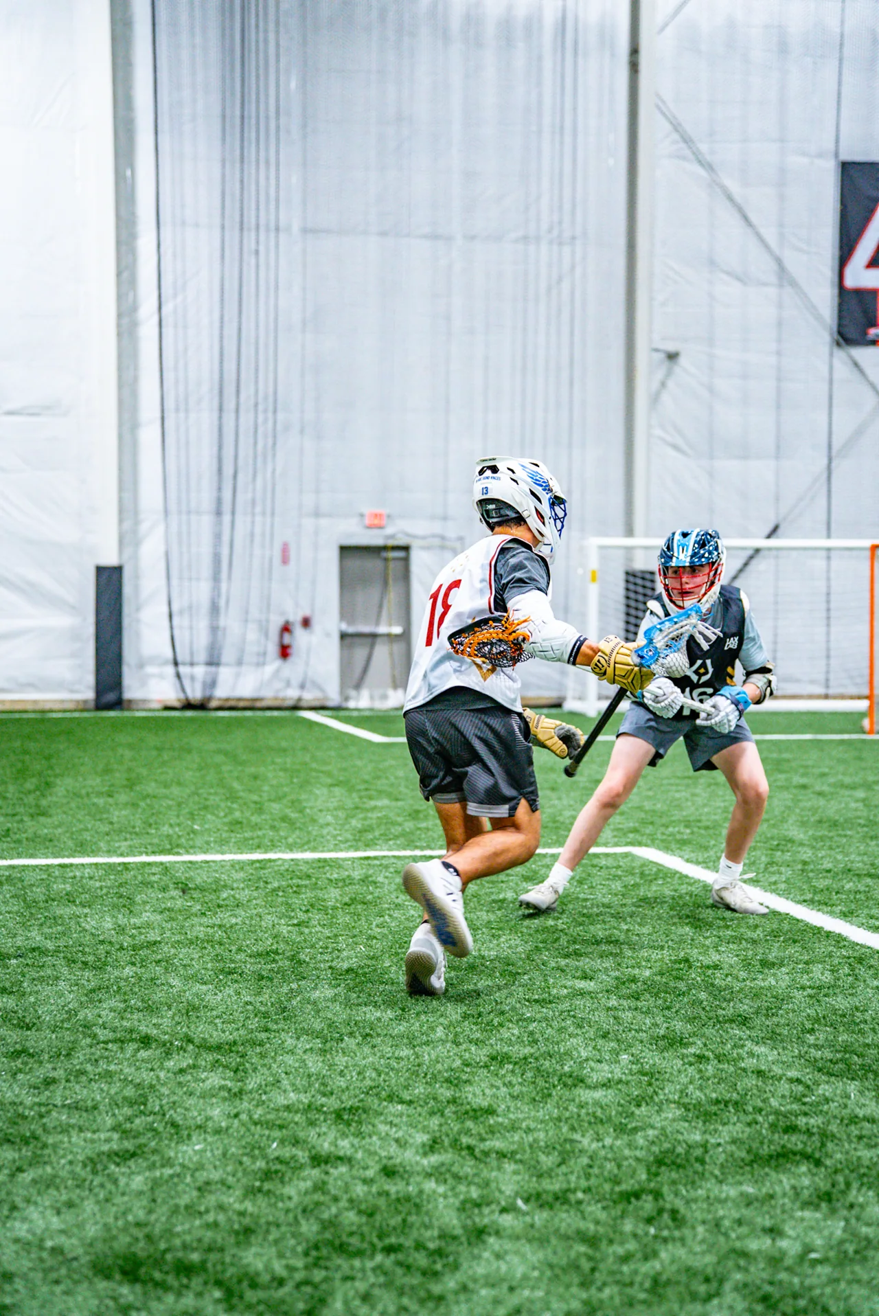 Lacrosse players run side by side during a practice drill